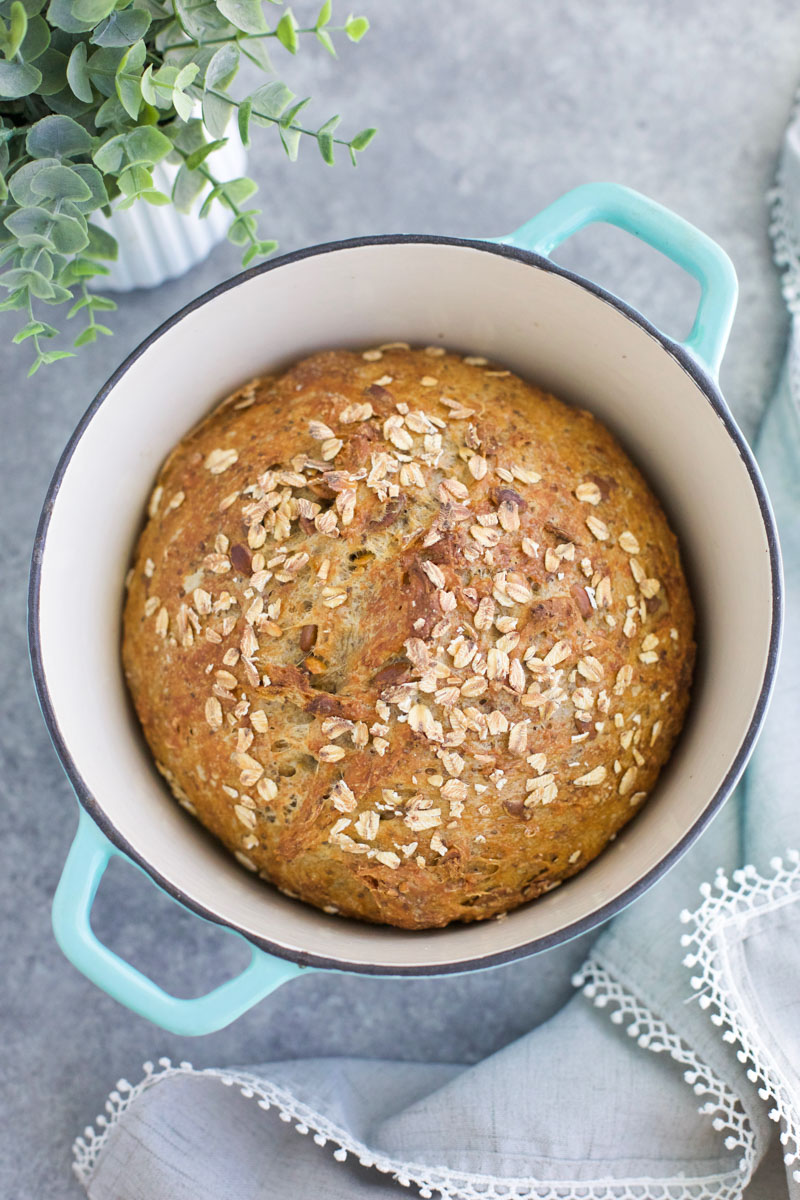 A loaf of bread in an aqua pot on a gray background. 