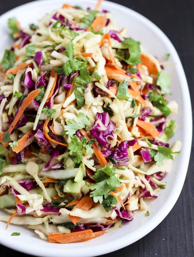 Ginger Asian coleslaw is packed with fresh flavors like ginger, peanut butter, apple cider vinegar, and cilantro! It's sweet, tangy, crunchy, and delicious as a side dish or to top burgers, sandwiches, and wraps!