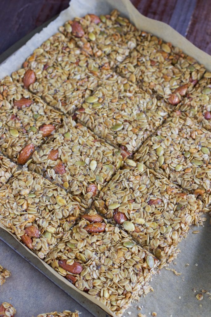 A full tray of granola bars on a parchment-lined tray.