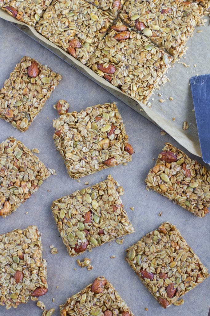 A parchment-lined tray filled with multiple vegan granola bars.