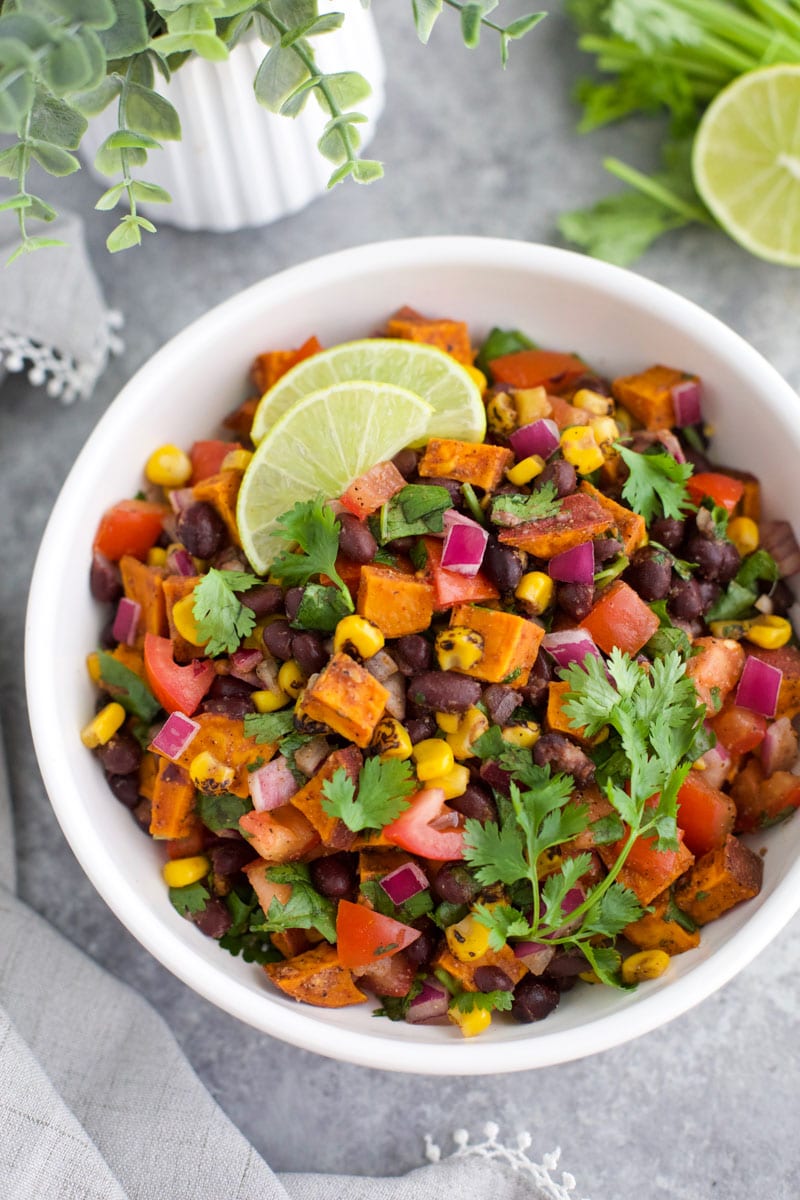 A white bowl filled with sweet potato salsa on a gray background.