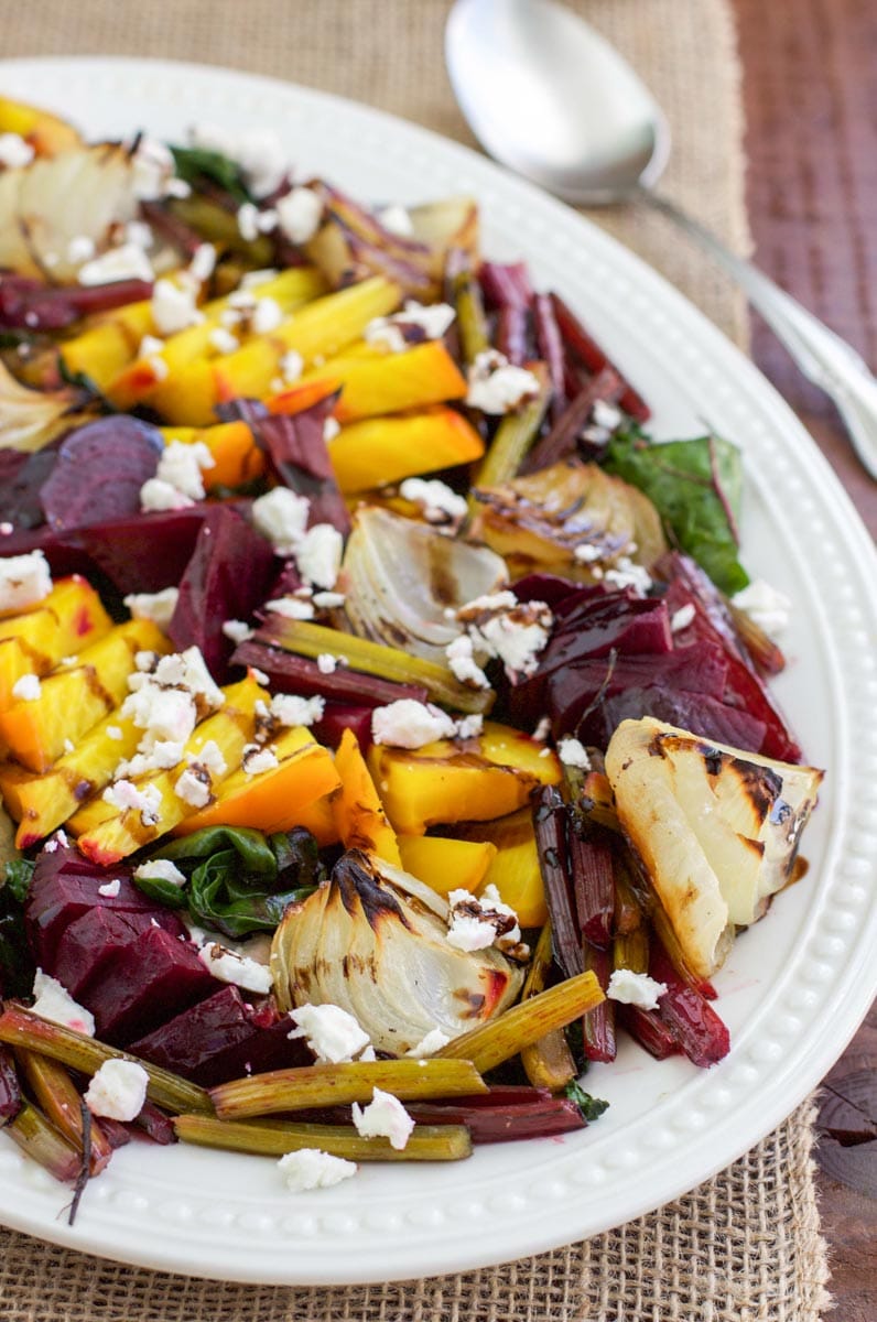 Side view of a white platter filled with roasted beet salad. 