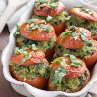 Roasted stuffed tomatoes that are filled to the brim with a flavorful mixture of pesto quinoa and fresh spinach. Vegan, dairy-free, and gluten-free.