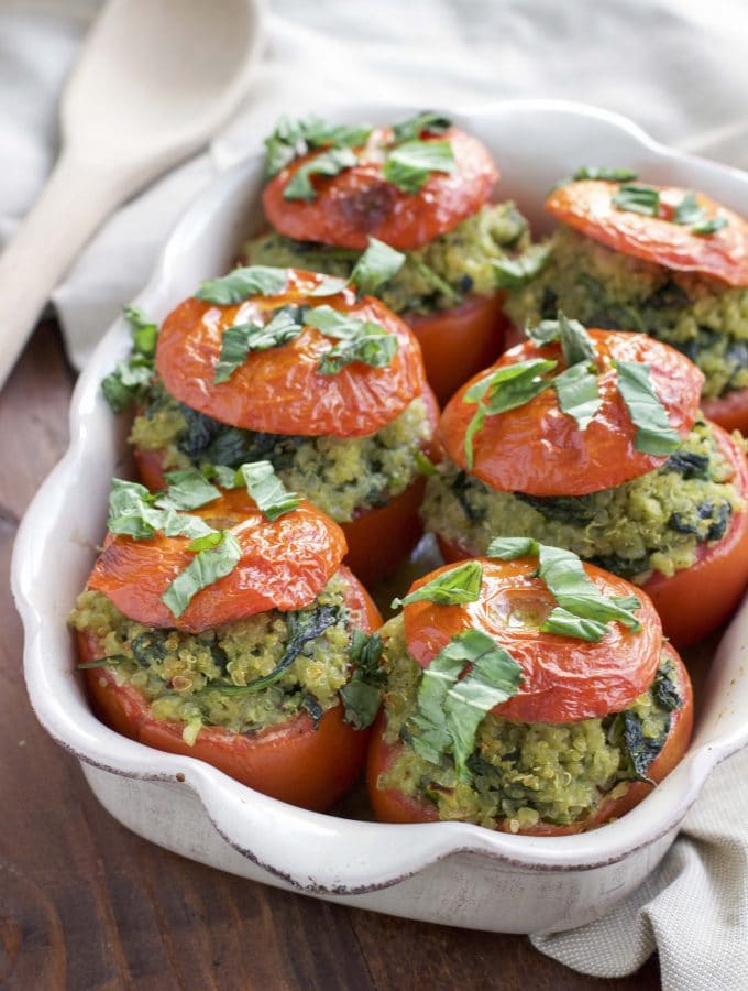 Roasted stuffed tomatoes that are filled to the brim with a flavorful mixture of pesto quinoa and fresh spinach. Vegan, dairy-free, and gluten-free.