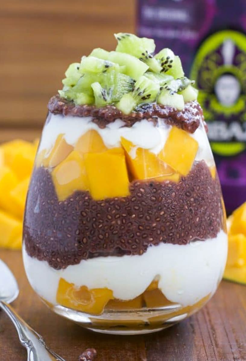 A close up shot of a vegan parfait filled with layers of fruit, vegan yogurt, and chia seed pudding.