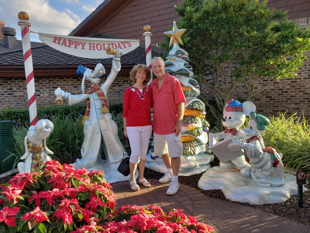 Free Christmas photo backdrop at Disney Springs with two people smiling. 