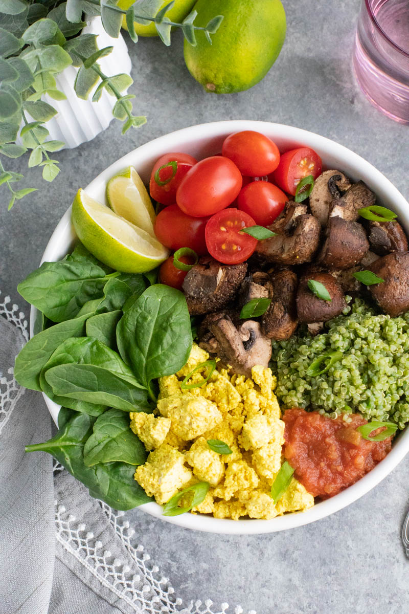 Overhead shot of a white bowl filled with vegetables on a gray background.