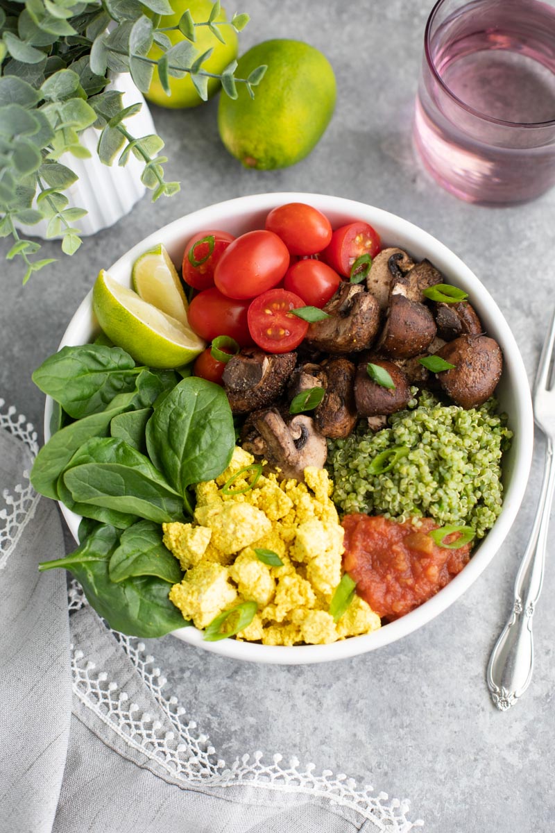 A white bowl filled with vegetables on a gray background. 