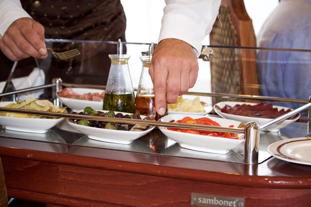 A man serving food from a charcuterie cart at Palo dinner. 