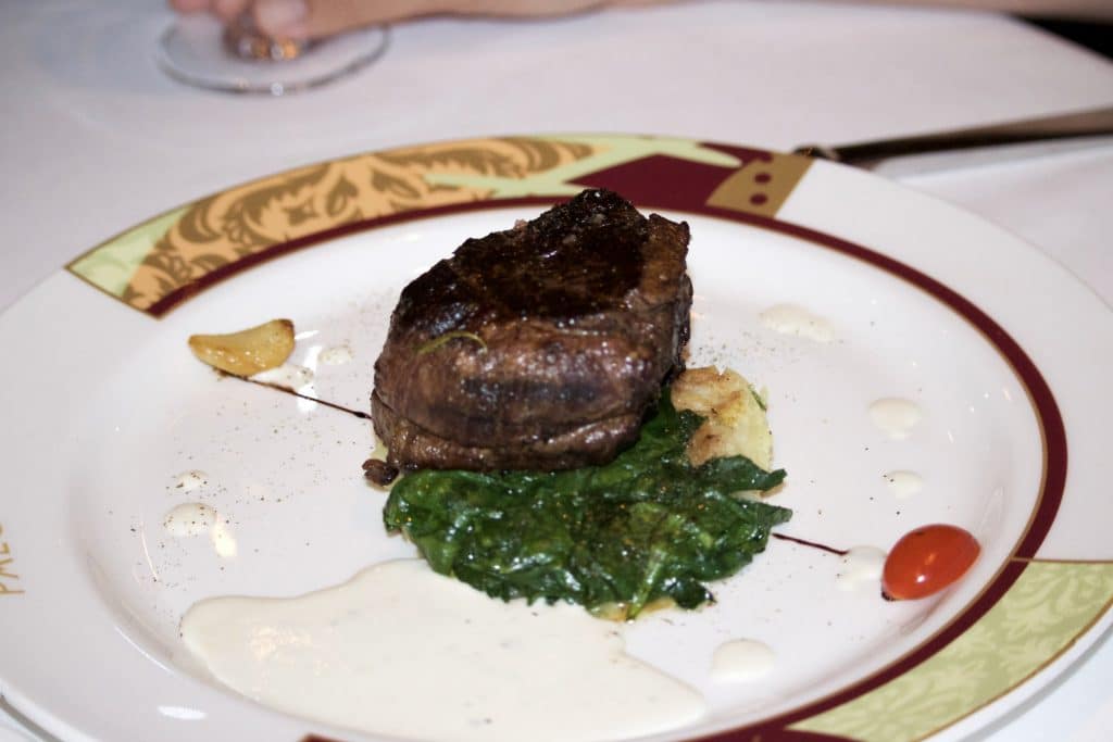 Beef tenderloin with blue cheese sauce on a bed of spinach on a plate at Palo for dinner. 