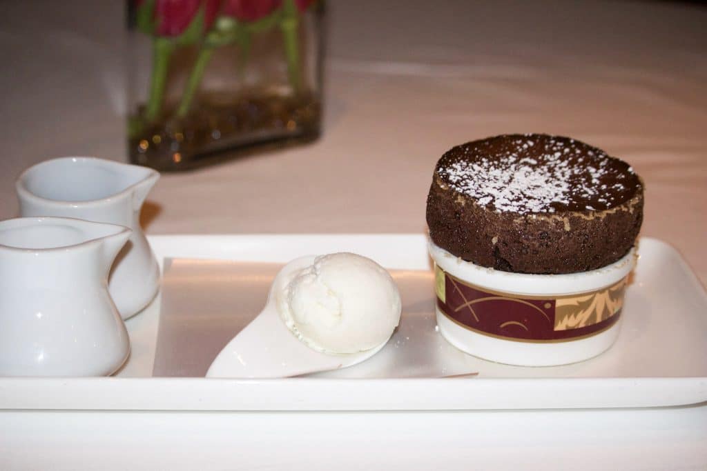 A chocolate souffle on a rectangular white plate with ice cream at Palo dinner. 