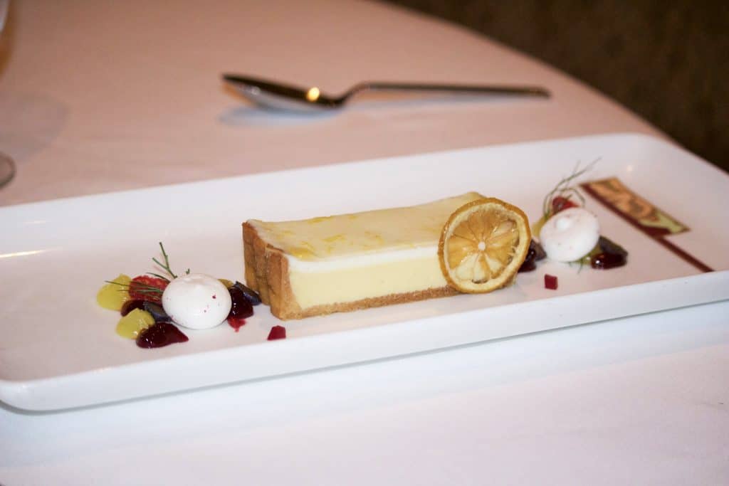 Limoncello tart on a rectangular white plate at Palo dinner on the Fantasy.