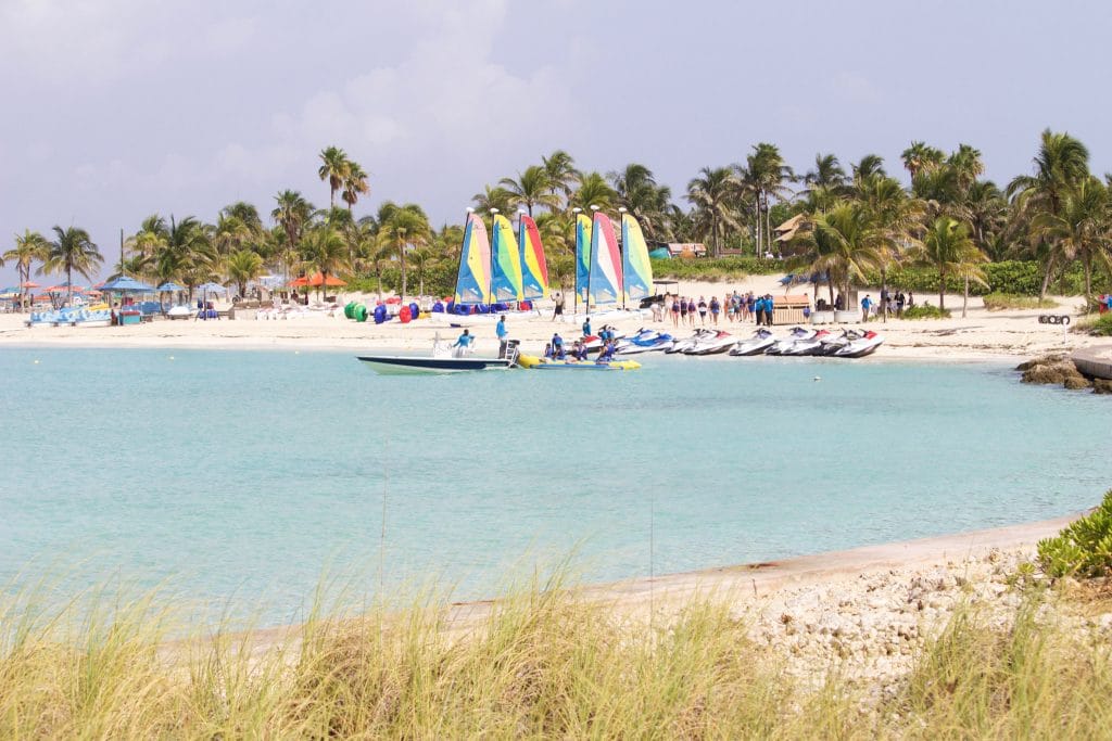 Palm trees, sailboats, jet skis, and the beach at Castaway Cay. 