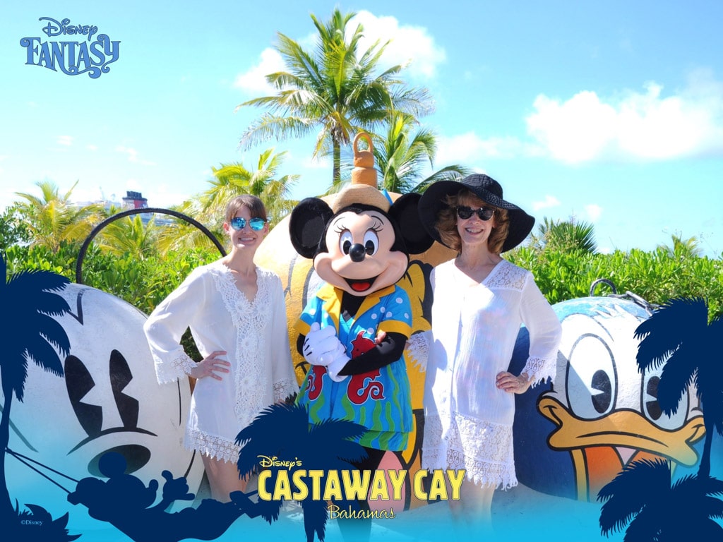 A mother and daughter smiling and posing for a picture with Minnie Mouse in front of Mount Rustmore at Castaway Cay. 