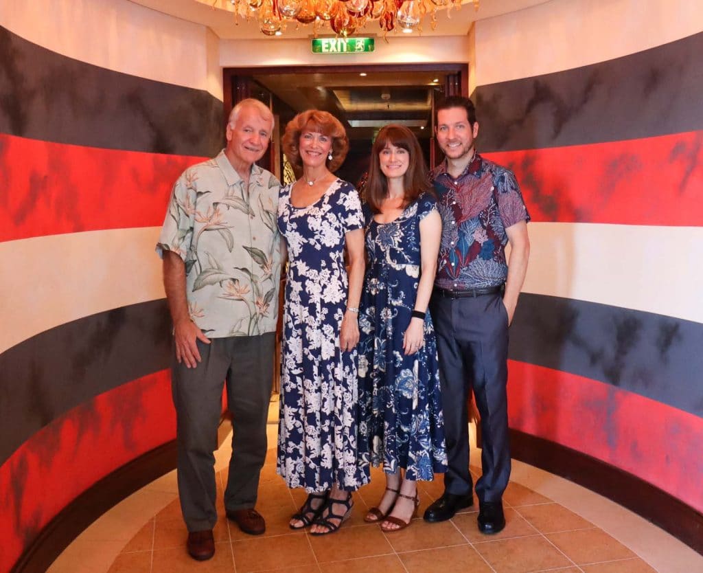 A smiling family posing at the entrance of Palo on the Disney Fantasy. 