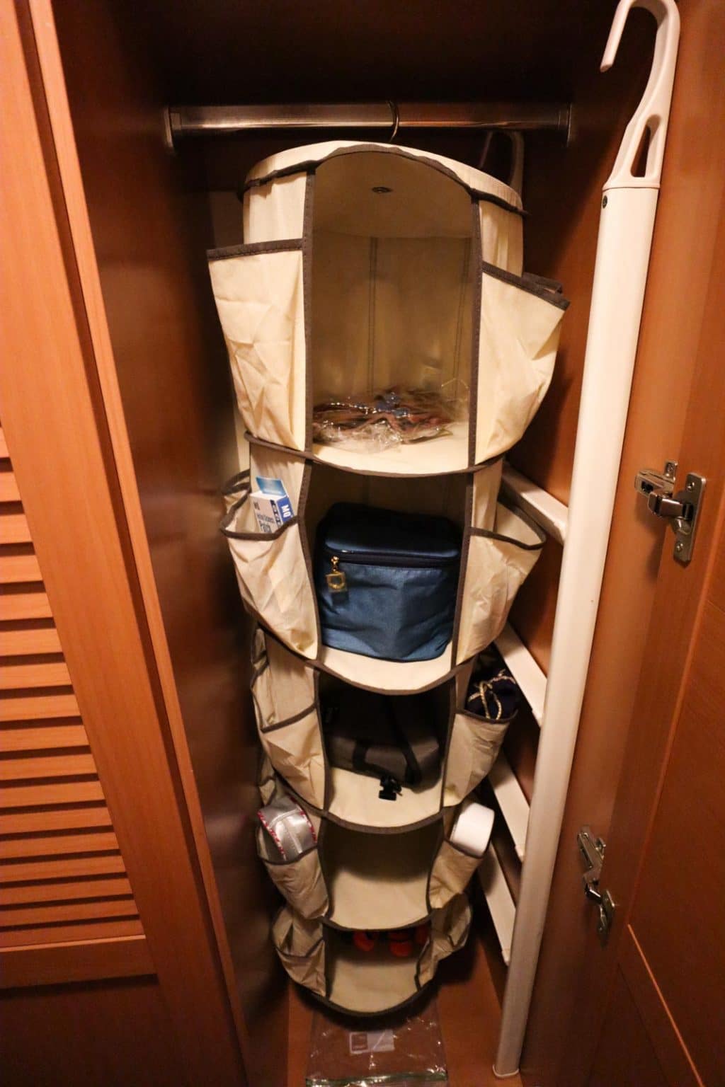 A spinning hanging organizer is hanging in the closet in a stateroom on the Disney Fantasy. 