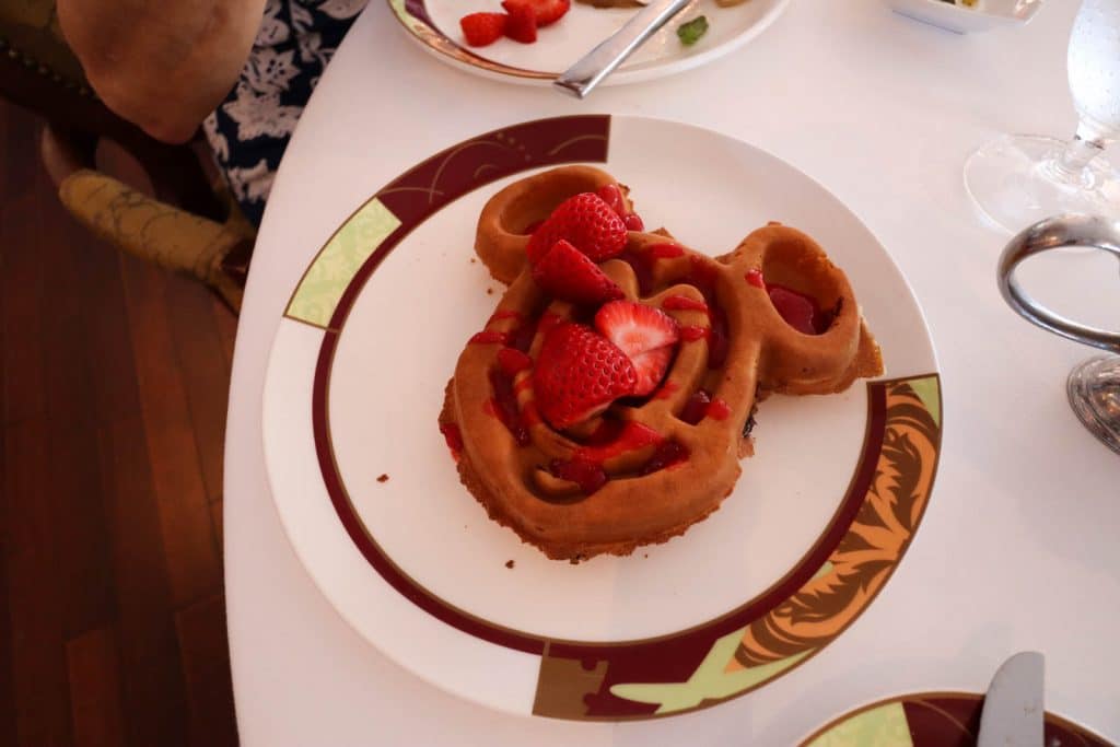 A giant mickey waffle with strawberries on a plate at Palo brunch on the Disney Fantasy.