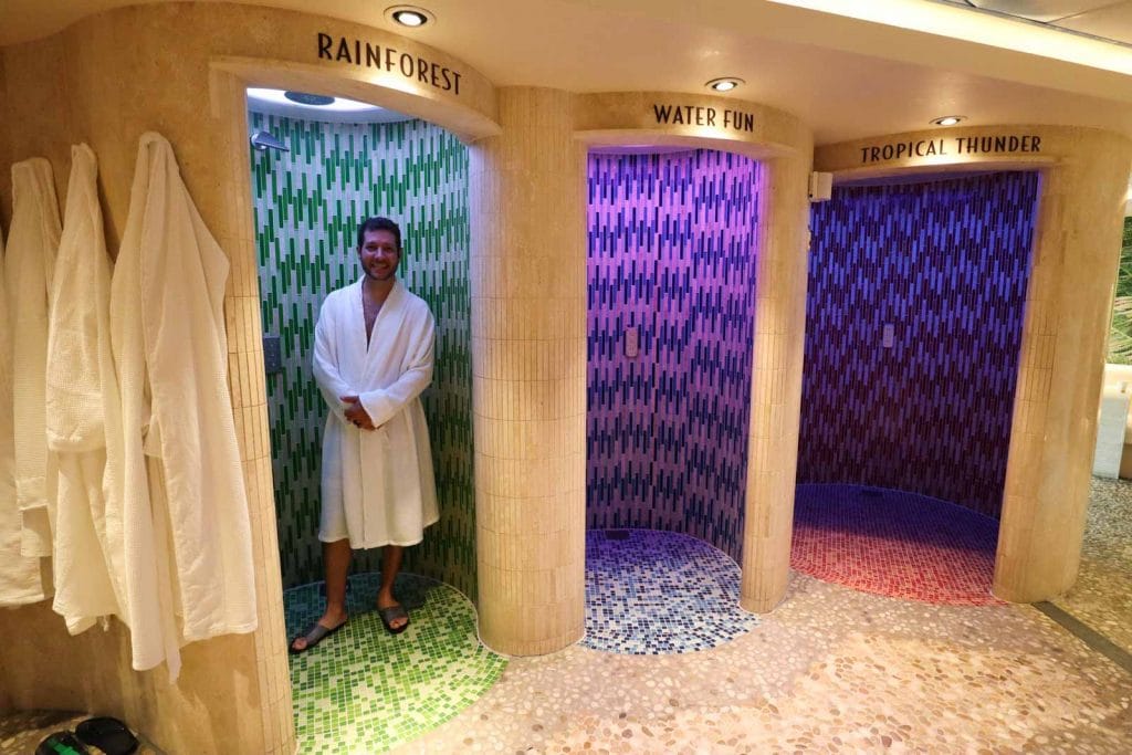 A man in a white bath robe standing inside the rainforest shower in senses spa on the Disney Fantasy.