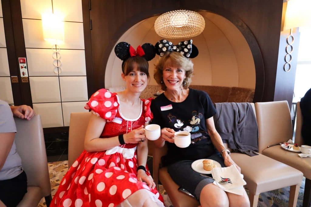 A mother and daughter dressed up for Halloween are holding coffee cups. 