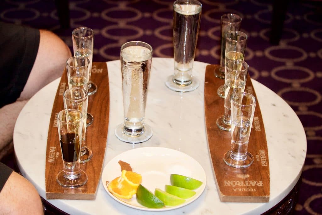 Tequila tasting trays on a white table with a plate of fresh limes on the Disney Fantasy.