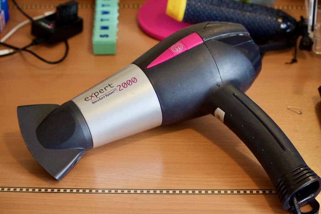 A hair dryer laying on a desk on a Disney cruise. 