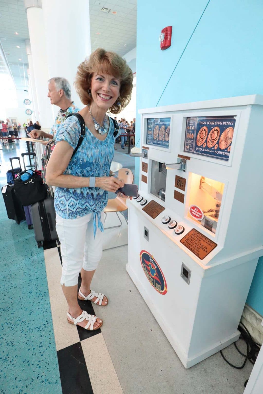 A woman using the pressed penny machine at the Port Canaveral cruise terminal.