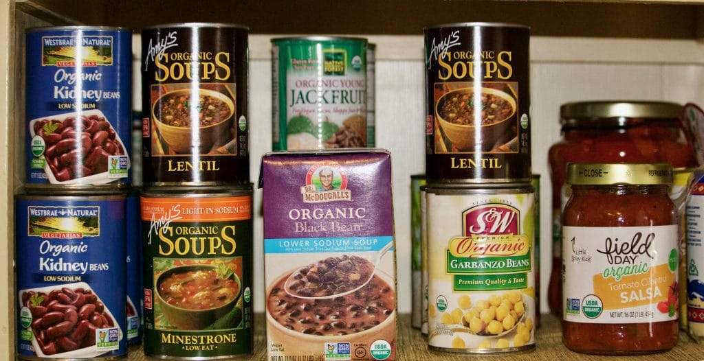 A pantry stockpile of vegan non perishable canned goods.