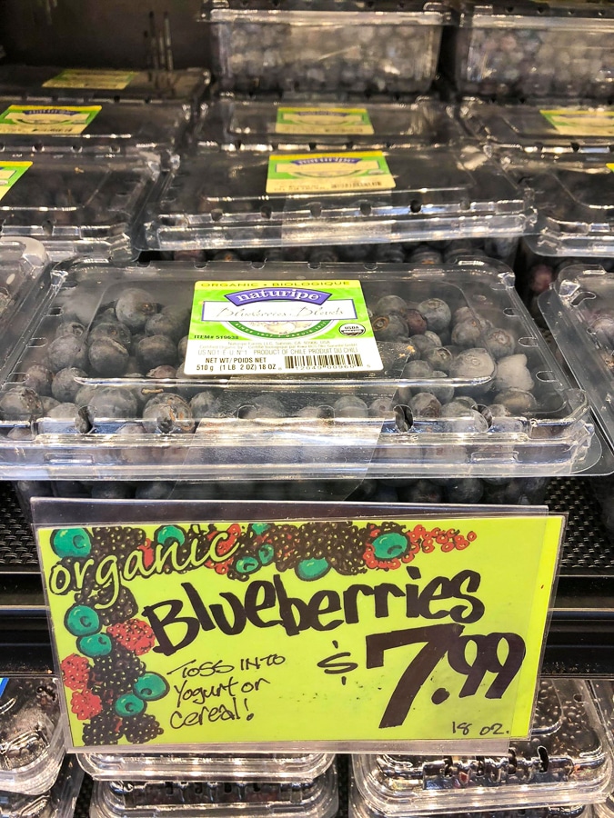 An 18 oz package of organic blueberries for $7.99 on a shelf at Trader Joe's. 
