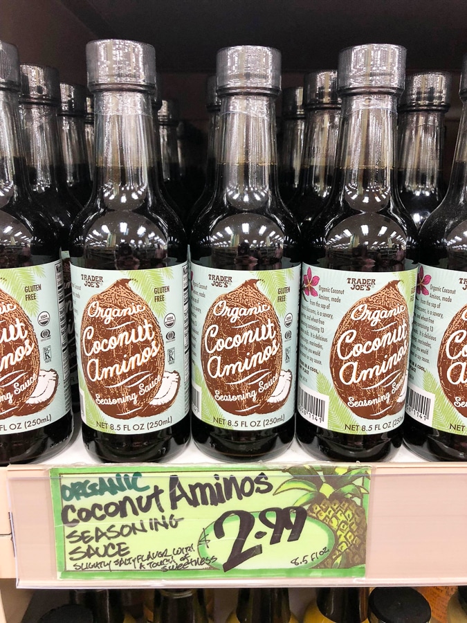 A shelf of organic coconut aminos in glass jars for $2.99 at Trader Joe's.