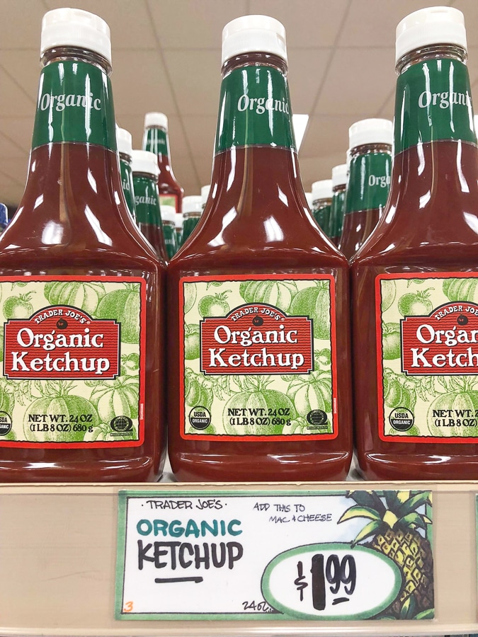 Bottles of organic ketchup on a shelf at Trader Joe's. 