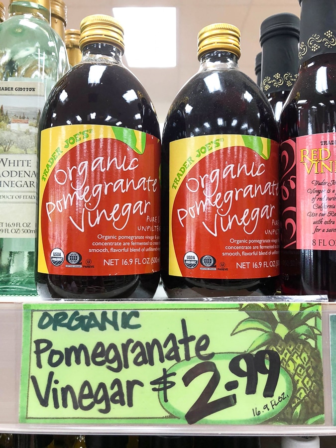Glass jars of organic pomegranate vinegar for $2.99 on a shelf at Trader Joe's. 