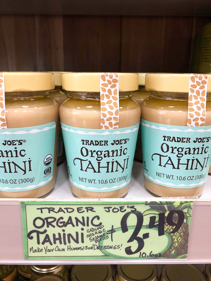 Glass jars of organic tahini for $3.49 on a shelf at Trader Joe's. 