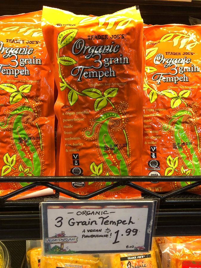 Packages of organic 3 grain tempeh for $1.99 on a shelf at Trader Joe's. 