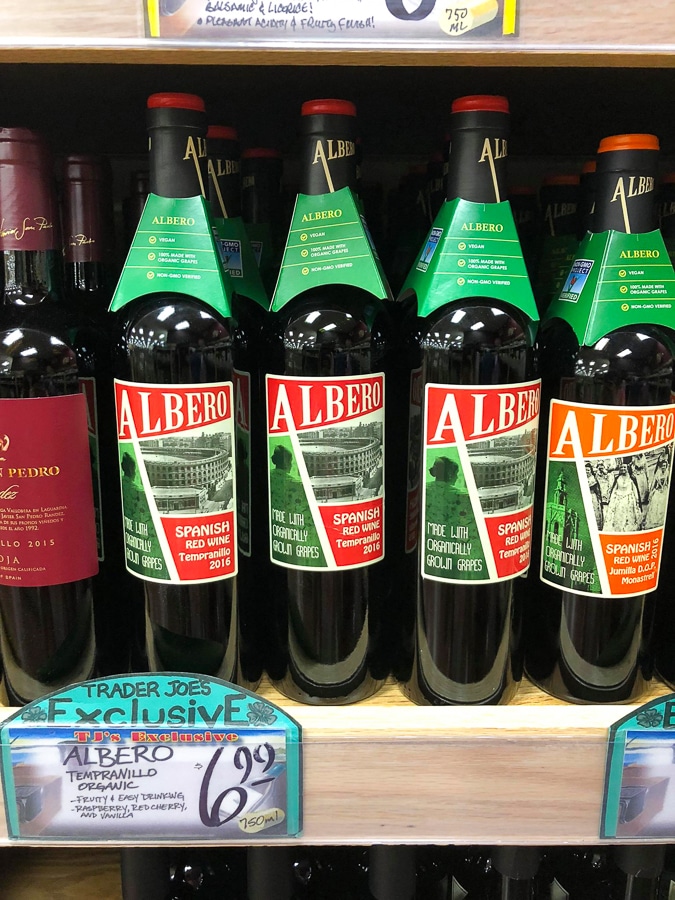 Multiple glass bottles of organic vegan wine on a shelf at Trader Joe's. 