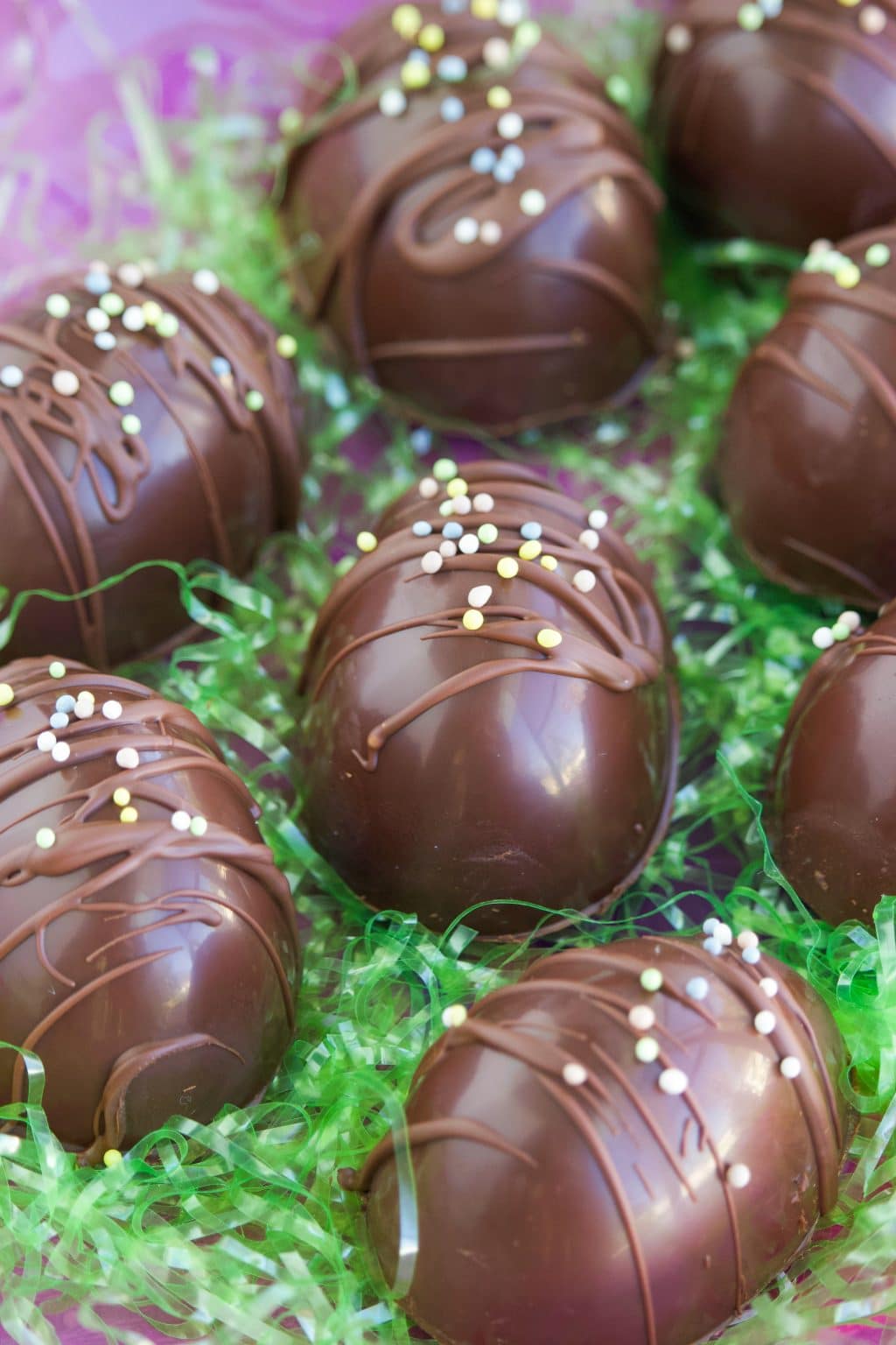 Chocolate eggs on a bed of green easter grass. 