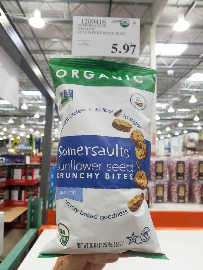 A hand holding a bag of organic vegan somersaults for $5.97 at Costco.