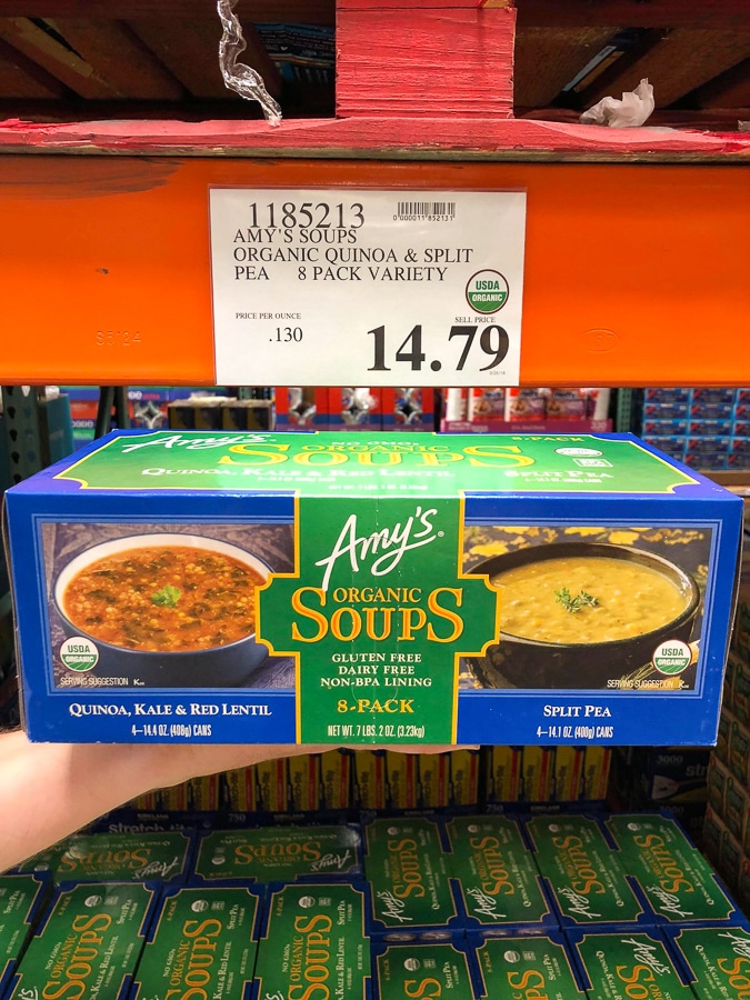 A hand holding a multipack box of organic vegan Amy's Soup for $14.79 at Costco.