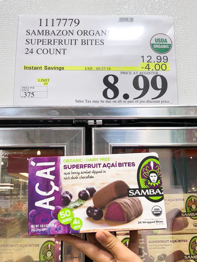 A hand holding a box of organic vegan Acai bites for $8.99 at Costco. 