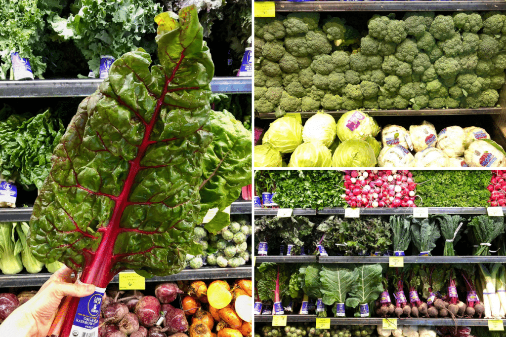 A hand holding a head of organic Swiss chard next to a wall of produce in the Produce section at Whole Foods. 