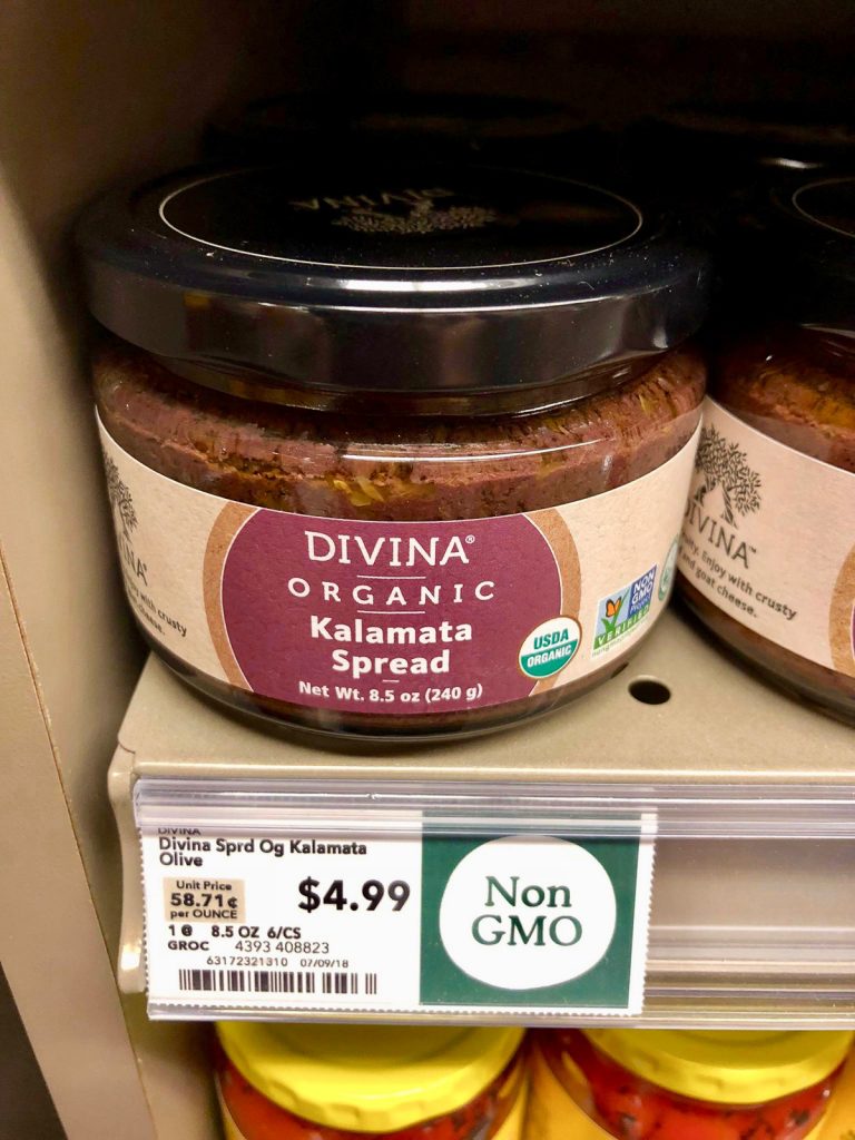 A glass jar of organic Kalamata spread on a shelf at Whole Foods. 