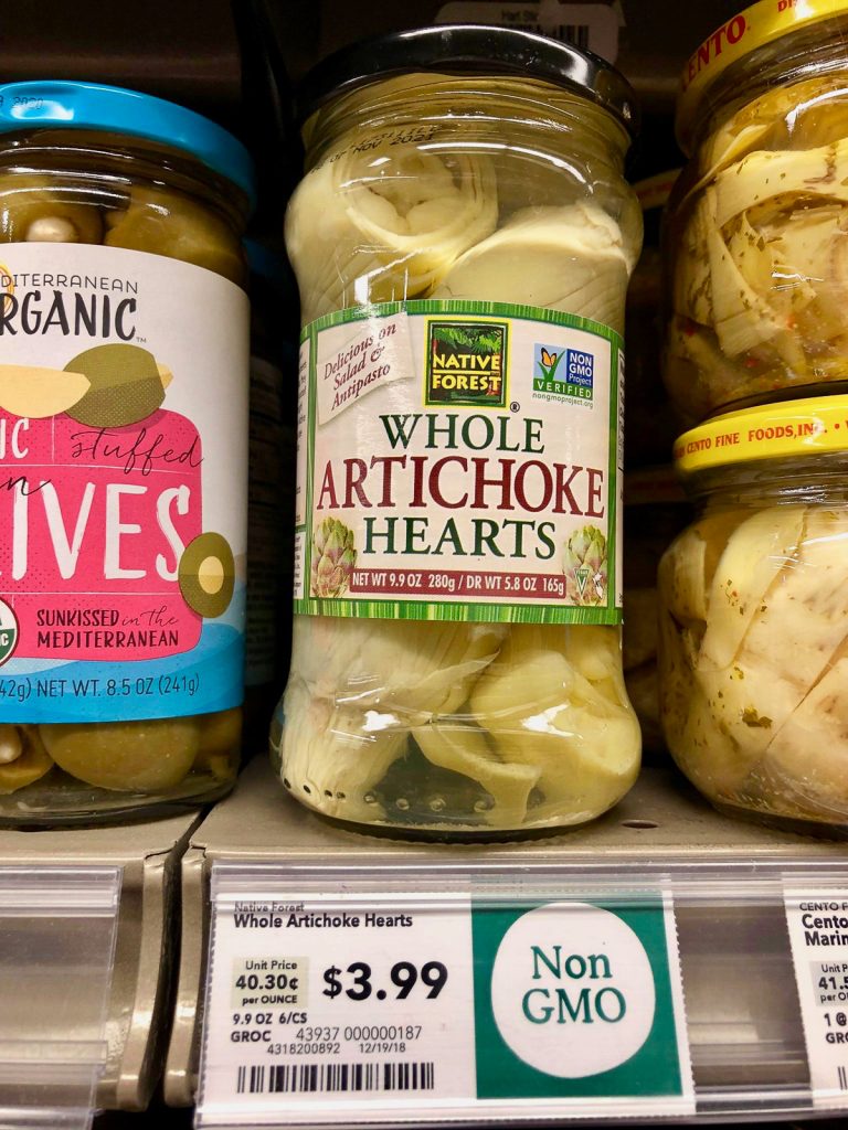 A jar of whole artichoke hearts on a shelf at Whole Foods. 