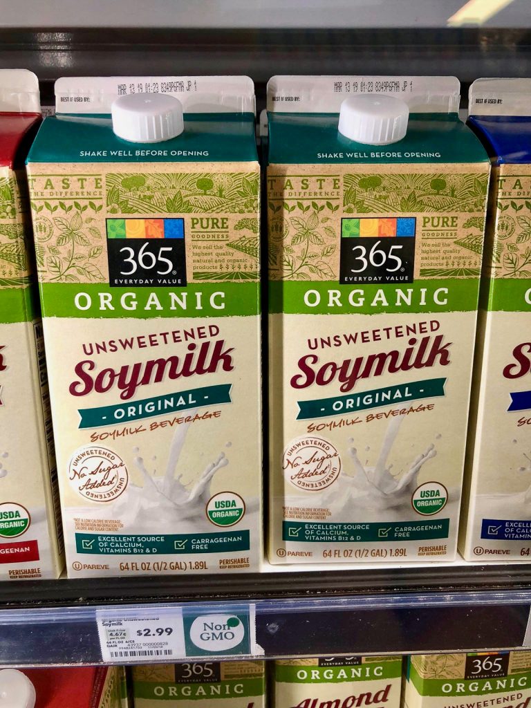 Two cartons of organic unsweetened soy milk on a shelf at Whole Foods. 