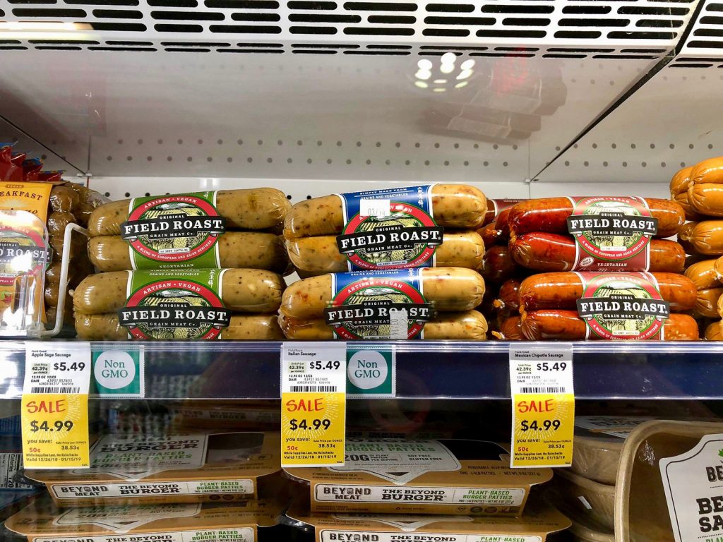 Multiple packages of Field Roast sausages on a shelf at Whole Foods. 