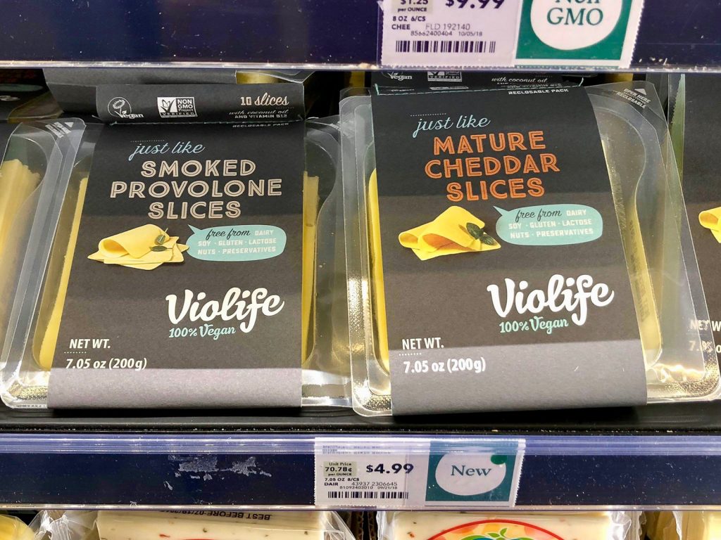 Two packages of Violife vegan cheese on a shelf at Whole Foods. 