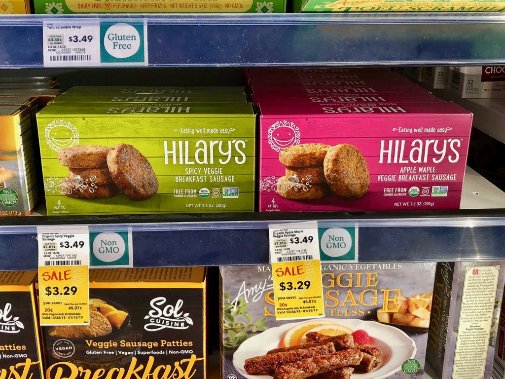 Multiple packages of Hilary's vegan products on a shelf at Whole Foods. 