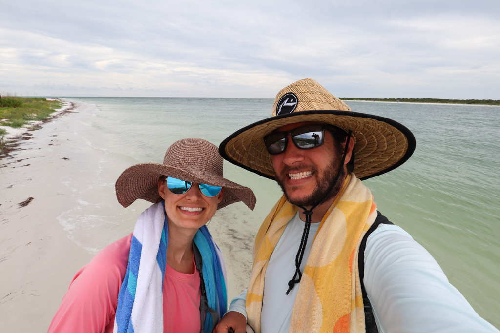 A smiling couple posing on the beach at Caladesi Island State Park. 