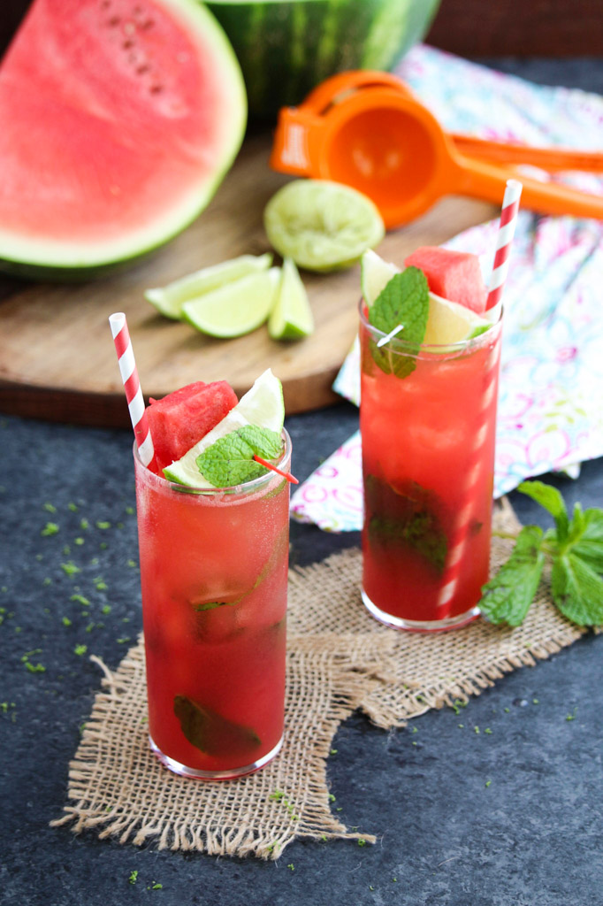 Two tall glasses filled with watermelon Moscow mule on burlap coasters. 