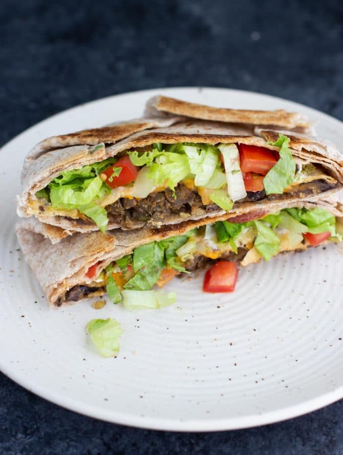 A vegan crunchwrap supreme on a white plate.