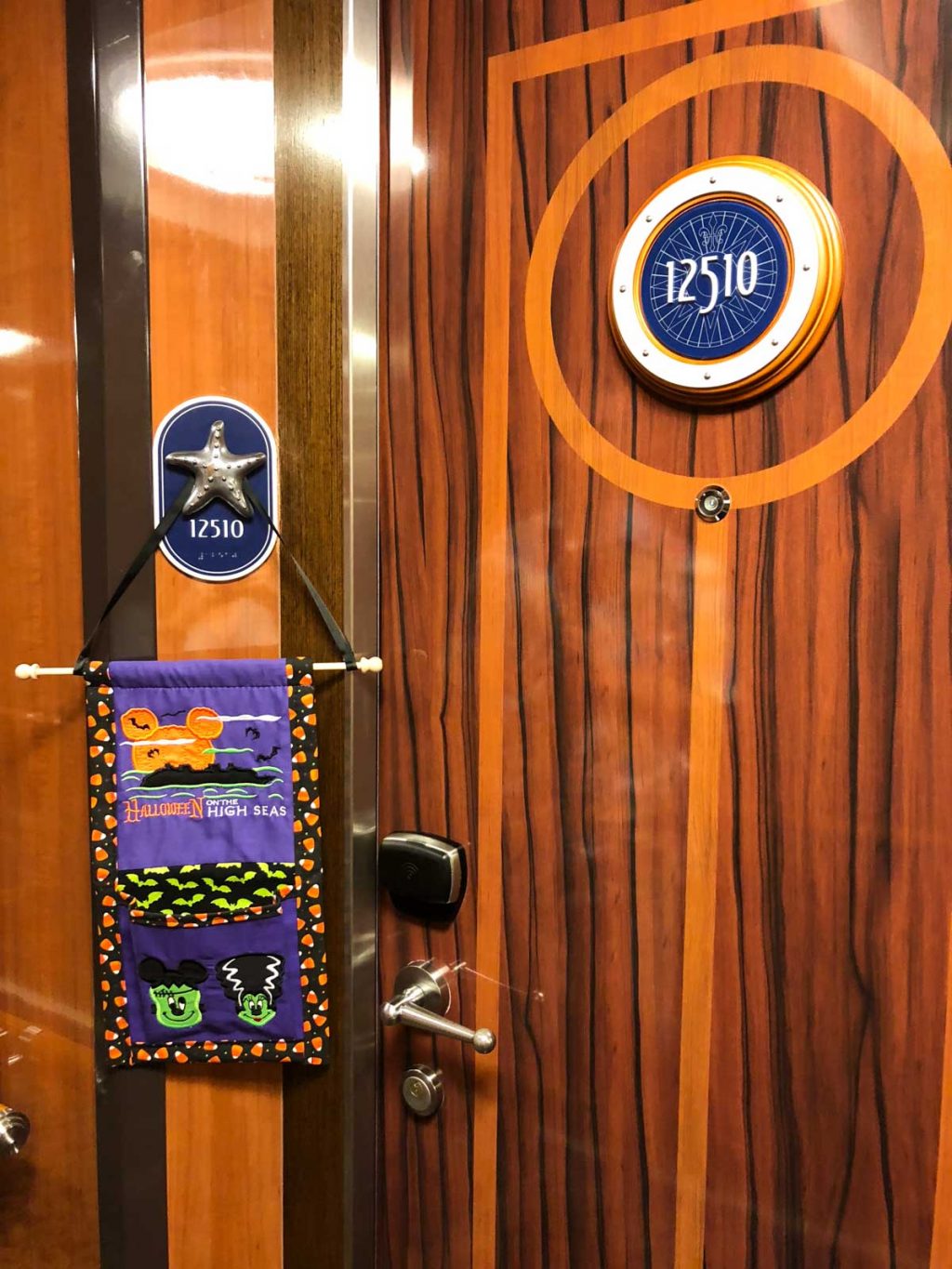 A purple fish extender hanging on a concierge stateroom door #12510 on the Disney Fantasy.