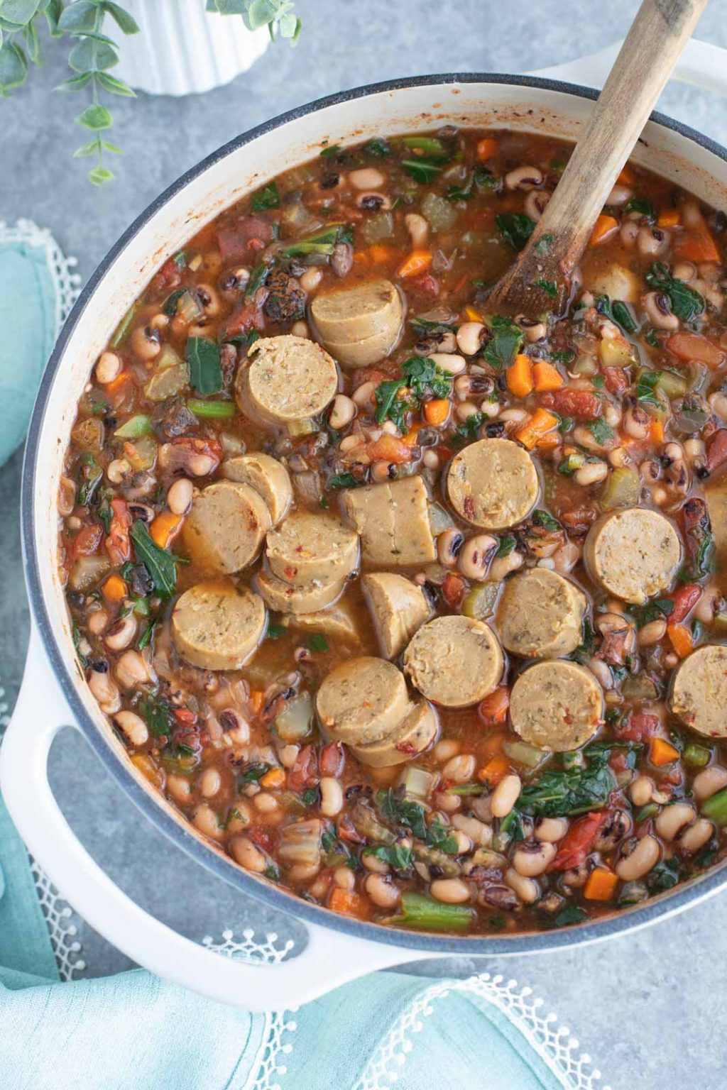 A white dutch oven filled with soup on a gray background.